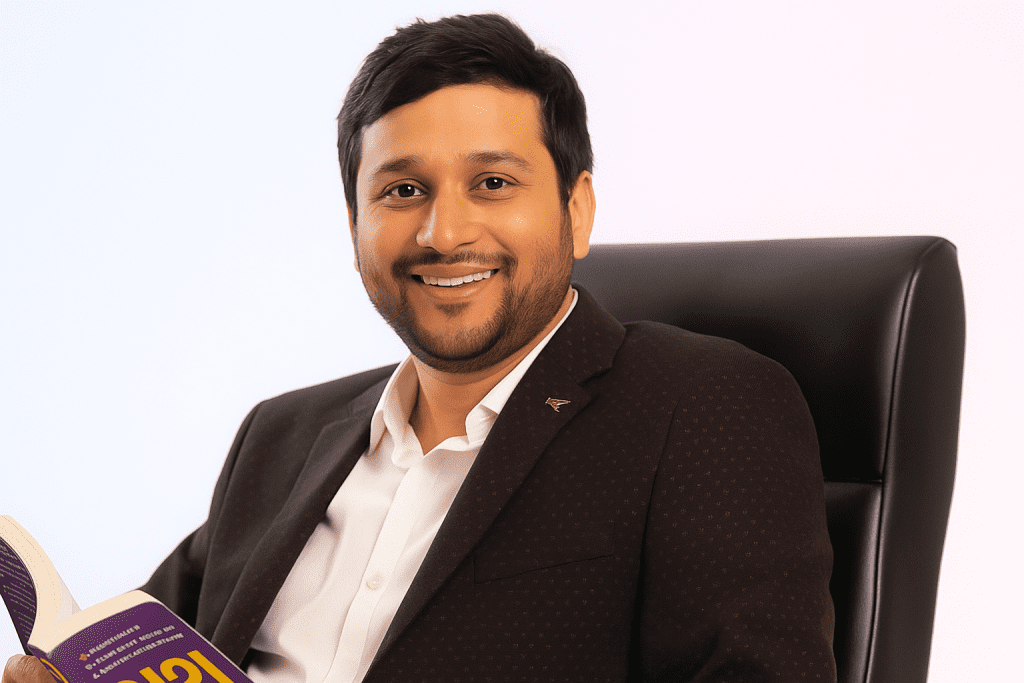 Dr. Amit Pareek, creator of Tube Engine AI, smiling in a professional office setting while holding a book, representing the developer behind the Tube Engine AI review product.